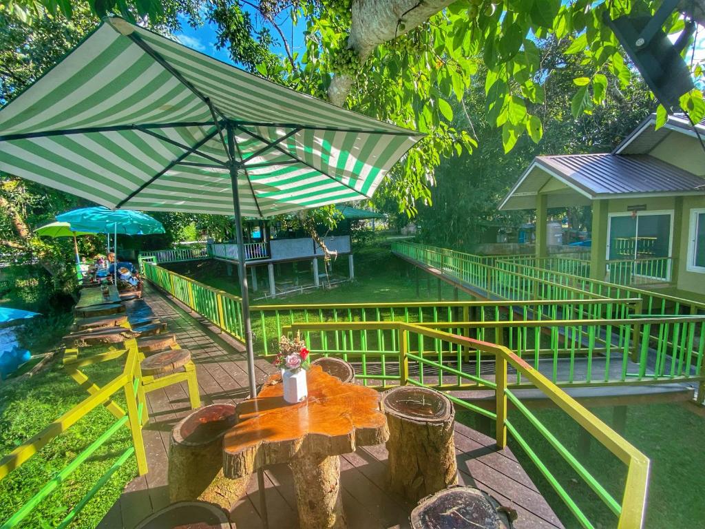 un patio con mesa y sombrilla en Ho Kho Coffee and Cottages, en Mae Hong Son