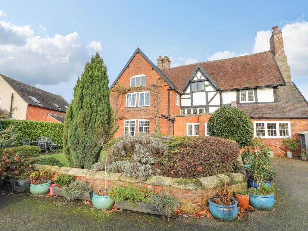 een huis met een bos planten ervoor bij The Manor House in Ashbourne