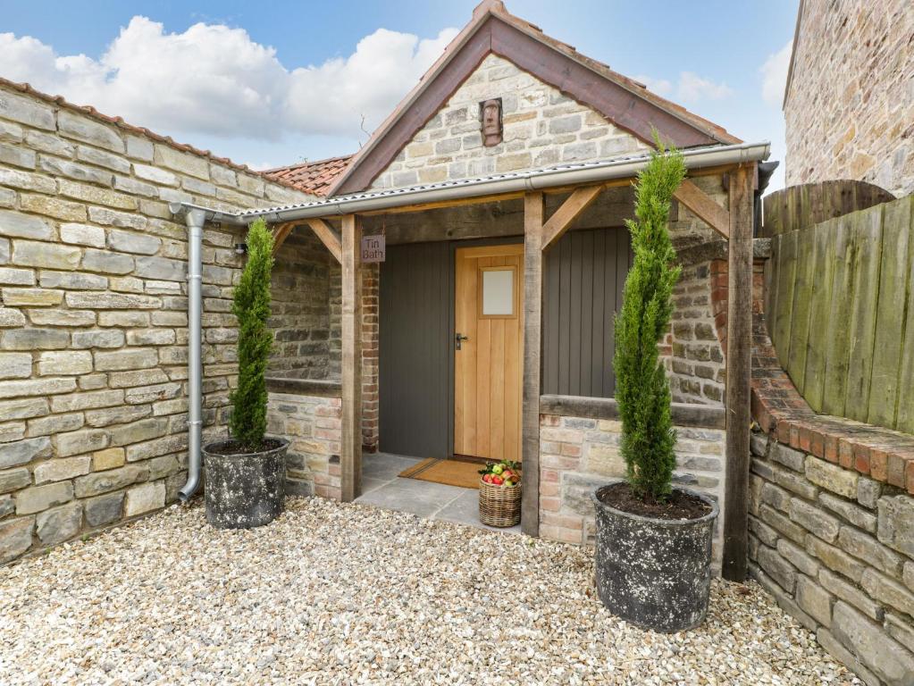 une maison en briques avec deux arbres devant une porte dans l'établissement Tin Bath, à Langport