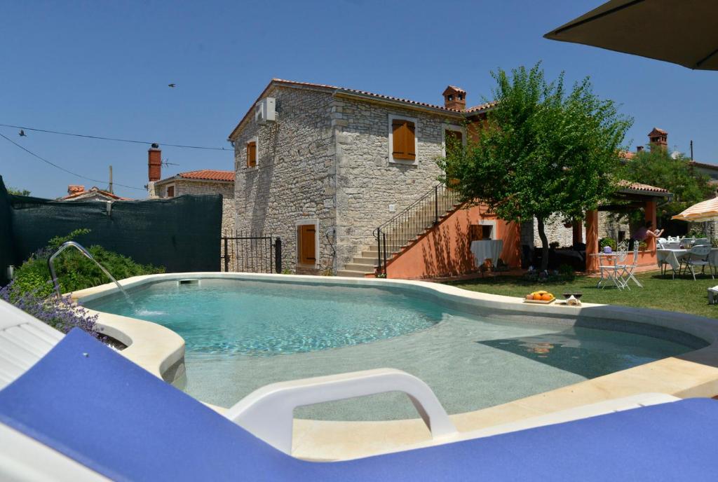 a large swimming pool in front of a house at Bed and Breakfast Casa Rustica in Vodnjan