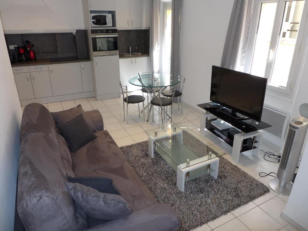 ein Wohnzimmer mit einem Sofa und einem Glastisch in der Unterkunft Central 1 bedroom Riouffe 2 mins from the Palais and Croisette 206 in Cannes