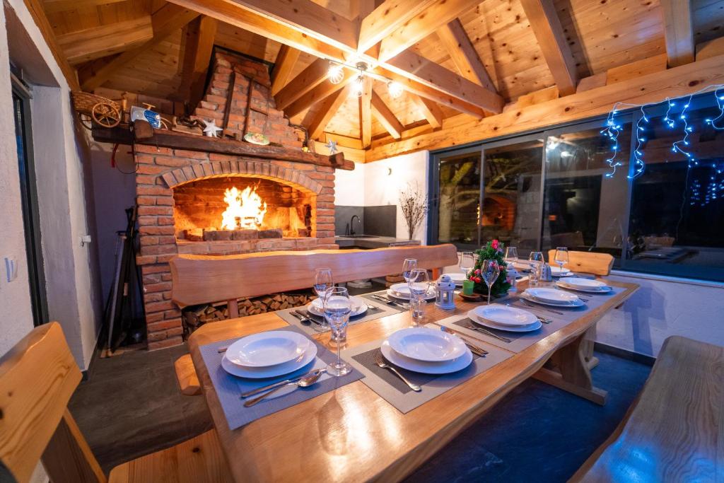 a dining room with a table and a fireplace at House Malkoc in Saborsko