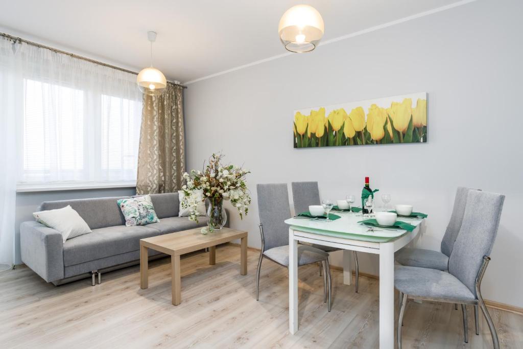 Osiedle Orła Białego Apartament Poznań في بوزنان: غرفة معيشة مع أريكة وطاولة