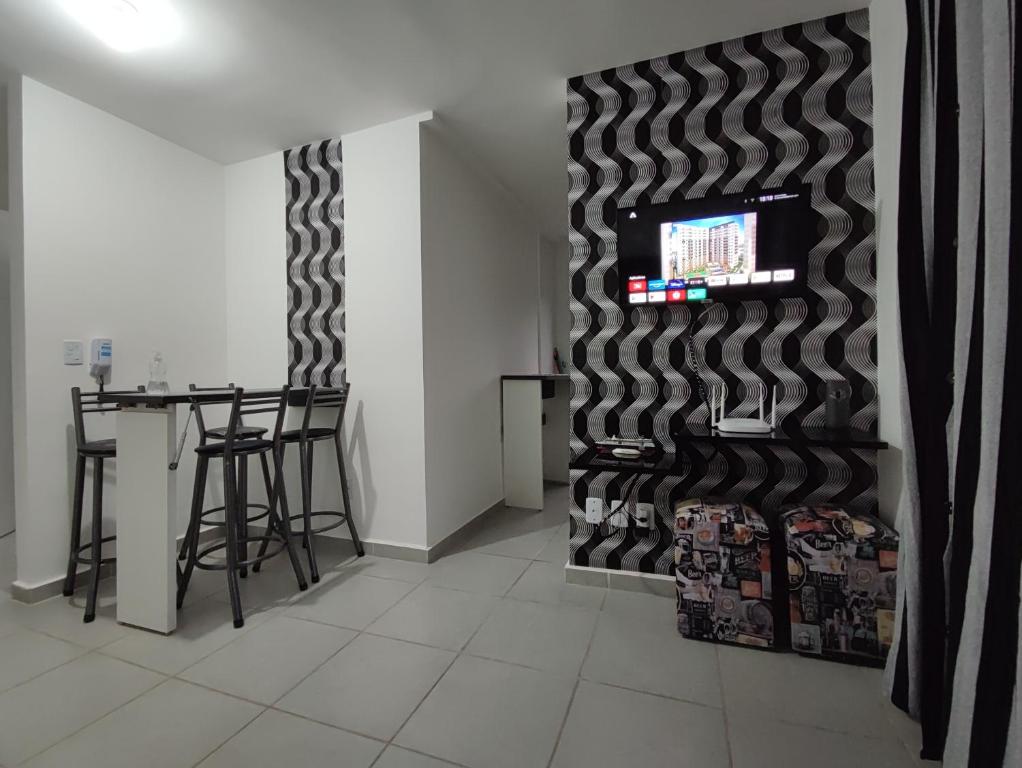 ein Esszimmer mit einer schwarz-weißen Wand in der Unterkunft Apartamento próximo ao shopping in Poços de Caldas