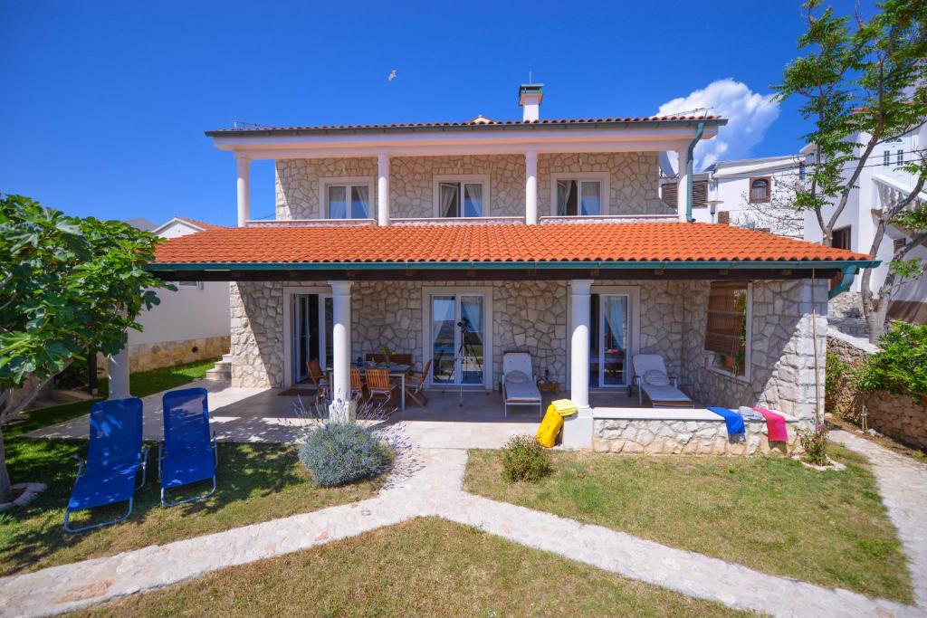 a house with blue chairs in front of it at Holiday Home Fiola in Zubovići