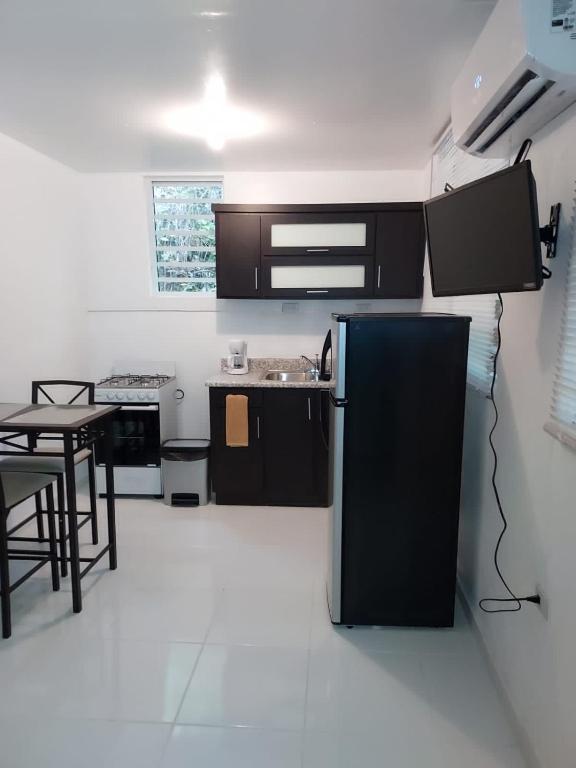 a kitchen with a black refrigerator and a table at Confort y Relajacion apto 5 in Dorado