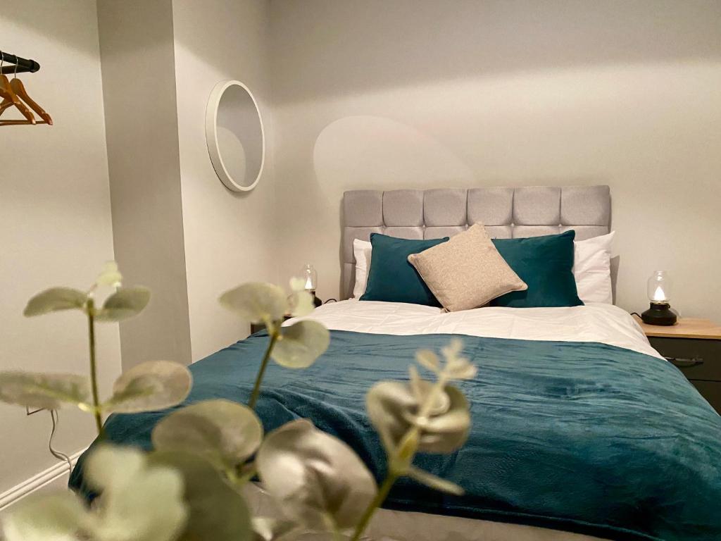 a bedroom with a bed with a blue blanket at ✪ Spacious Luxury 2-bed w/ parking & garden in Killingbeck