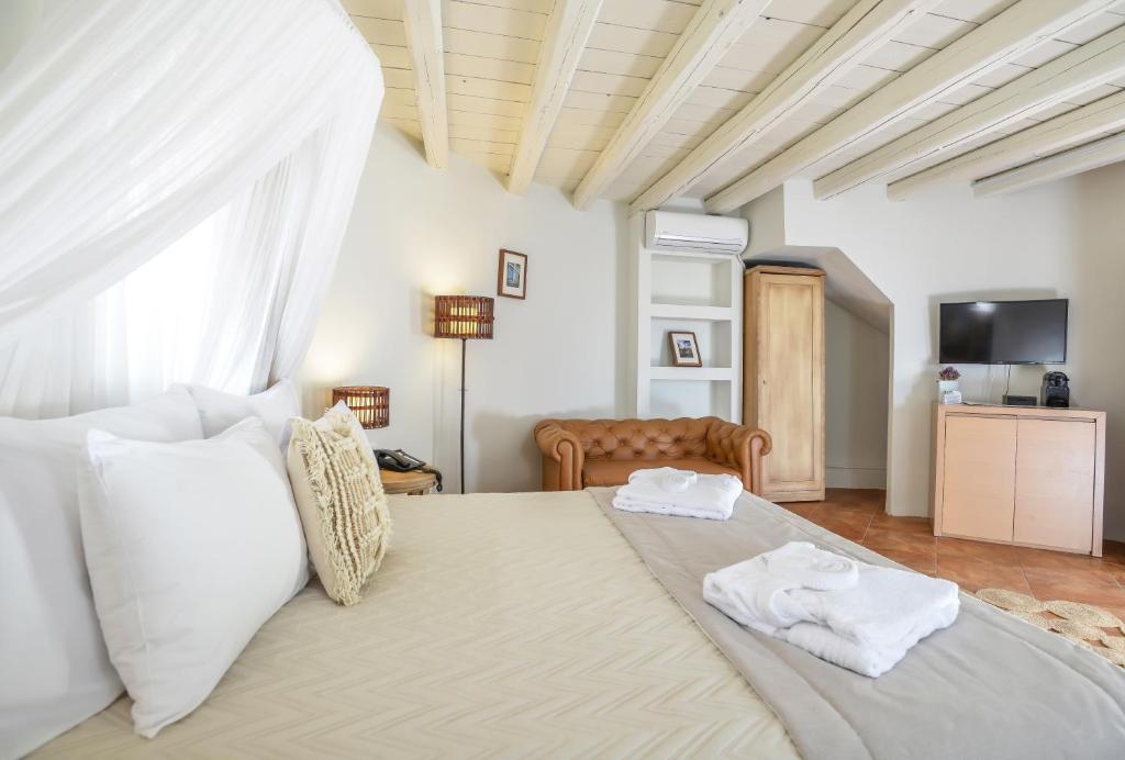 a bedroom with a large bed with two towels on it at Varos Village Boutique Hotel in Város