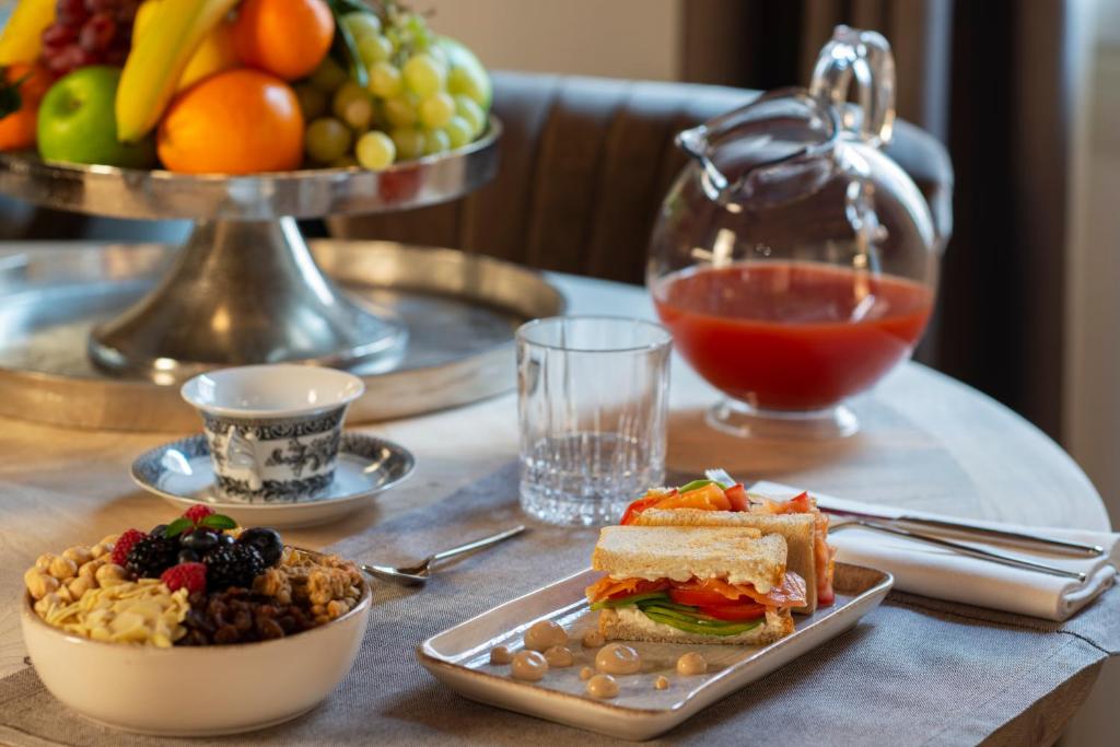 una mesa con un plato de comida y un bol de fruta en ELEGANCE ROOM - Aparta & Suite - Automatized Apartment, en Bassano del Grappa