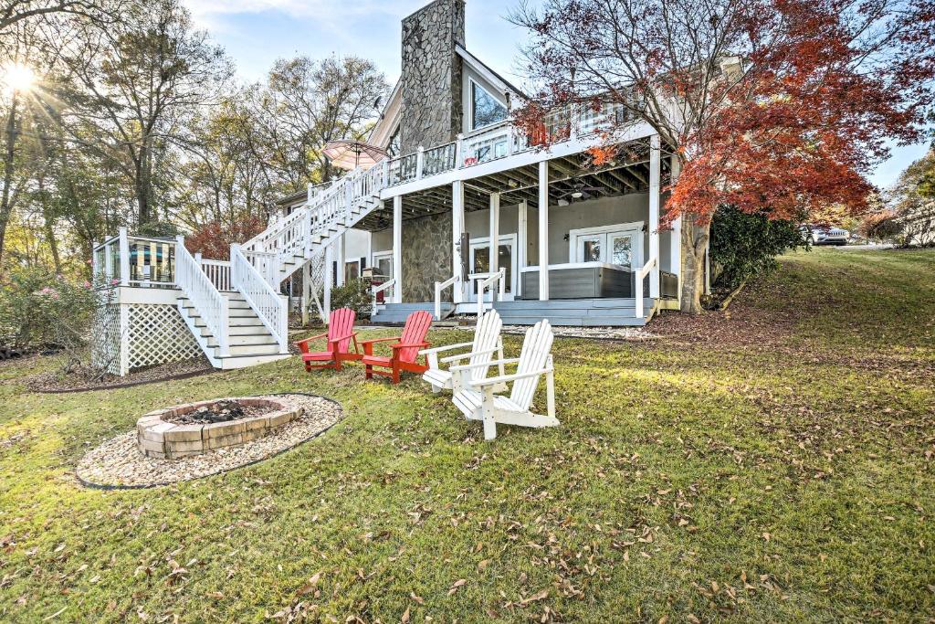 a house with chairs and a fire pit in the yard at Lake Hartwell Home with Private Dock and Hot Tub! in Lavonia