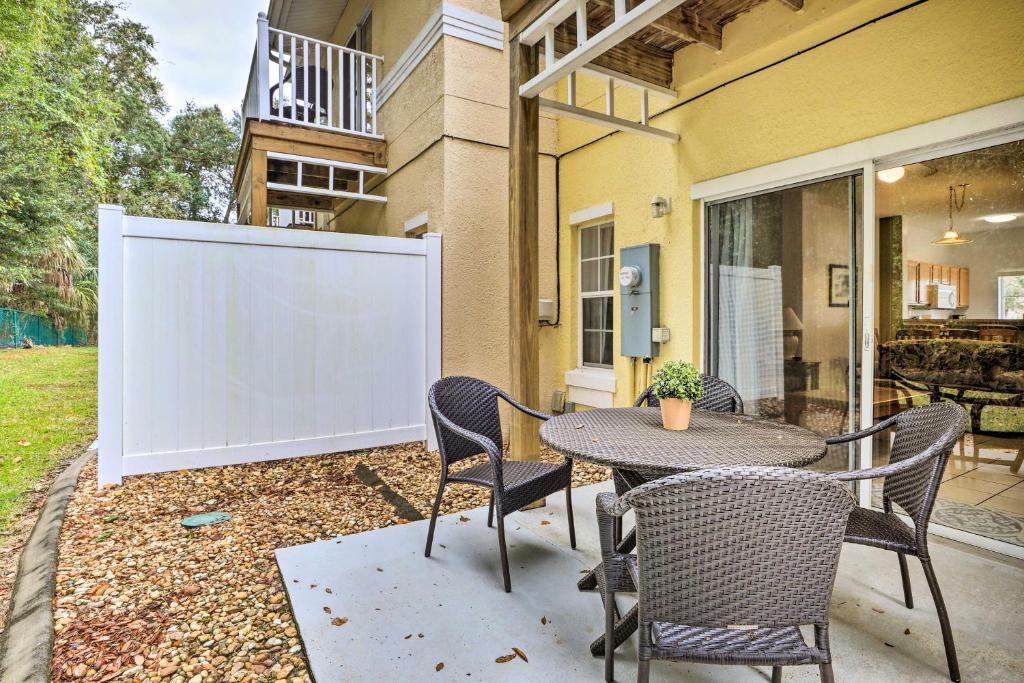 een patio met een tafel en stoelen en een groot scherm bij Stunning Kissimmee Townhome Less Than 8 Miles to Disney! in Kissimmee