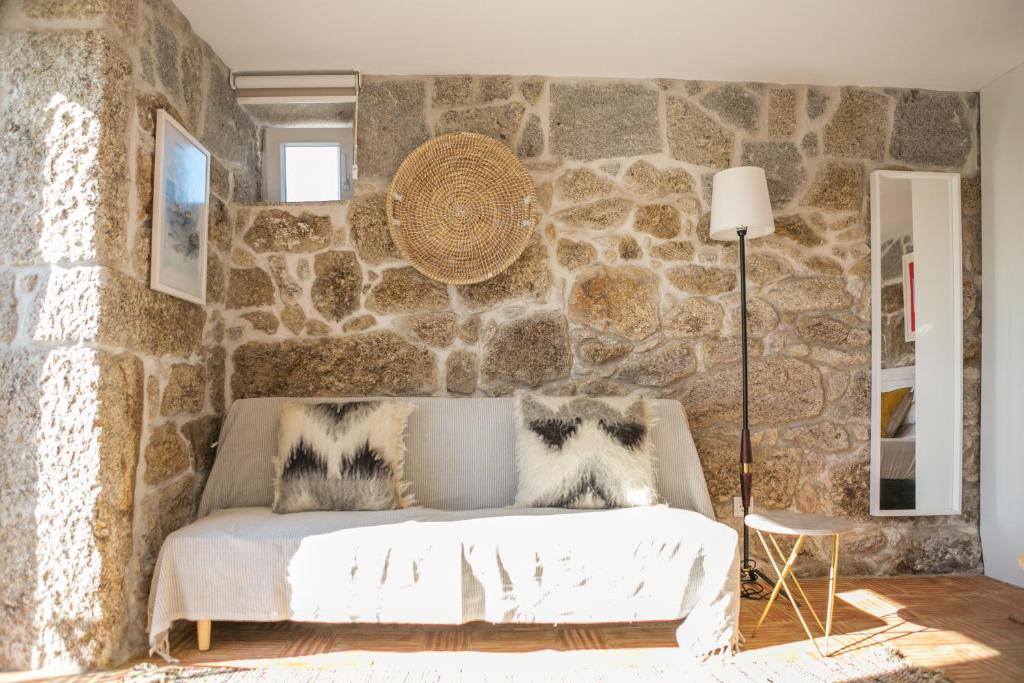 a bedroom with a stone wall with a bed at Casa Monte do Cervo in Vila Nova de Cerveira