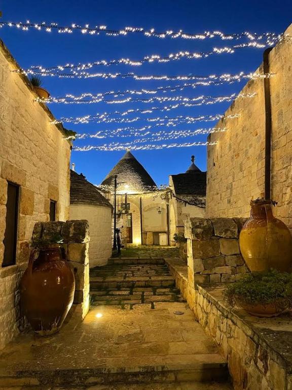 an alley with vases and clouds in the sky at Il Gabellota Resort in Alberobello