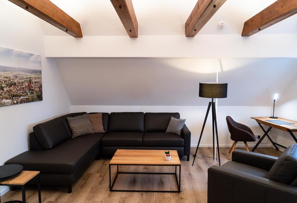 uma sala de estar com um sofá e uma mesa em AMBERG [APART] - Wohnung [CITY] - Wohnraum auf Zeit em Amberg