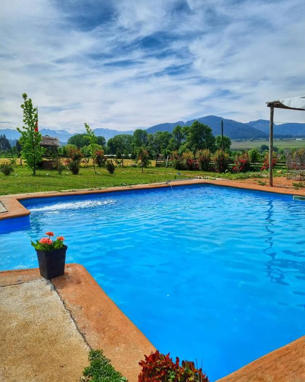 a blue swimming pool with mountains in the background at Mauleuvu Outdoor, alojamiento bed and breakfast y actividades outdoor in Talca