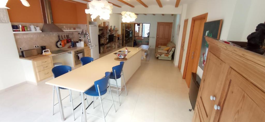 a kitchen with a white table and blue chairs at Apartamentos Pou, bloque con tres apartamentos independientes, reformados, confortables, y a la playa andando in Villajoyosa