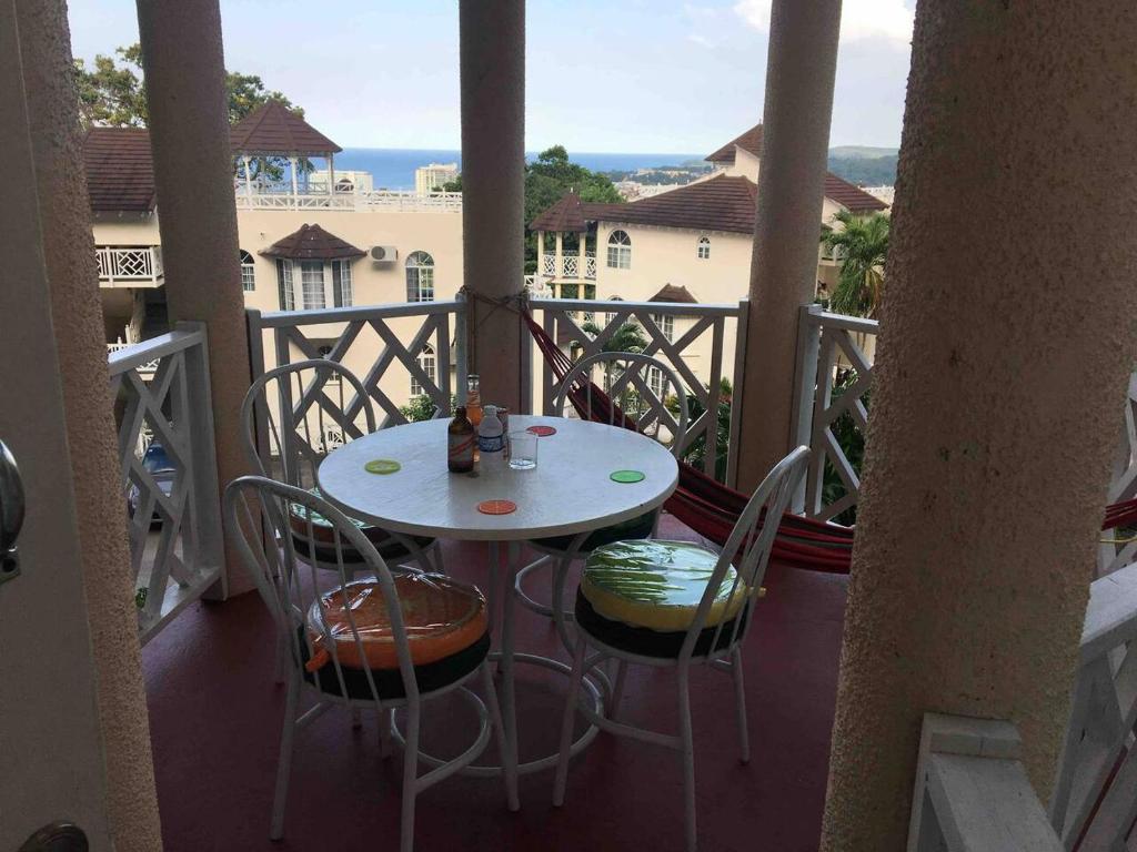 a table and chairs on a balcony with a view at Immaculate 1-Bed Villa in Ocho Rios in Ocho Rios