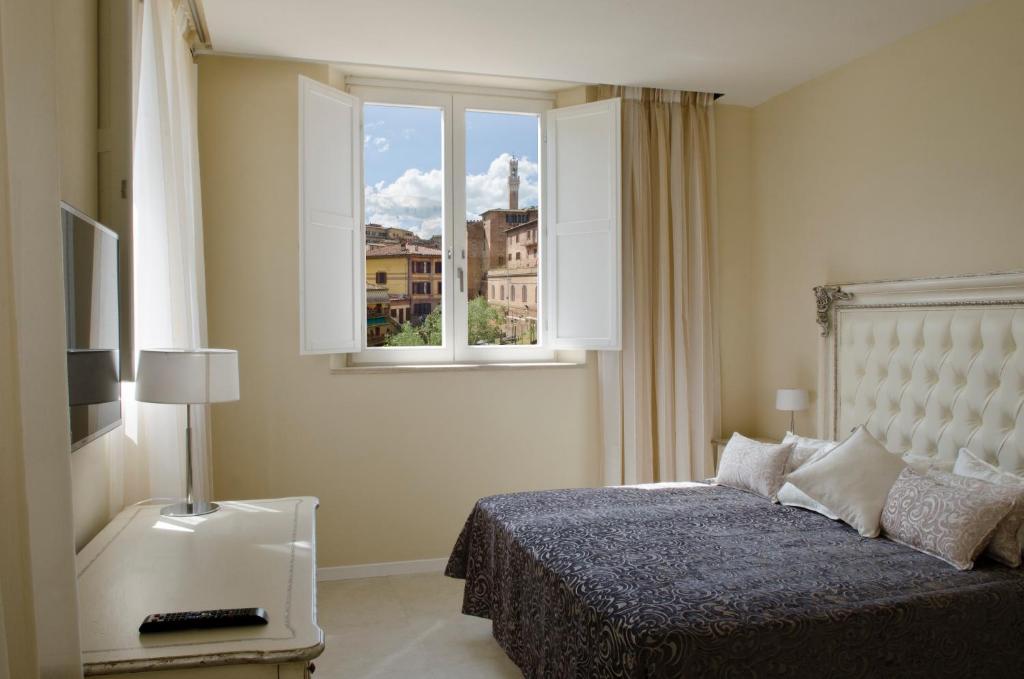 A bed or beds in a room at Villa del Sole Siena