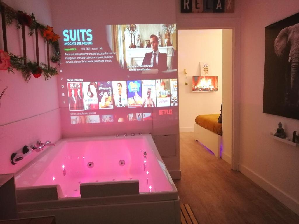 a bathroom with a hot tub with pink lighting at Le 1965 Double BALNEO, confort et romantique in Grenoble