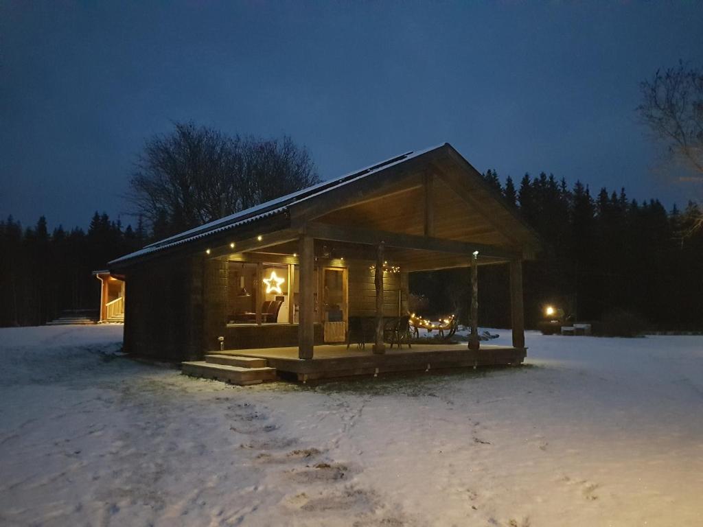 eine kleine Holzhütte im Schnee in der Nacht in der Unterkunft Stordrågen in Kil