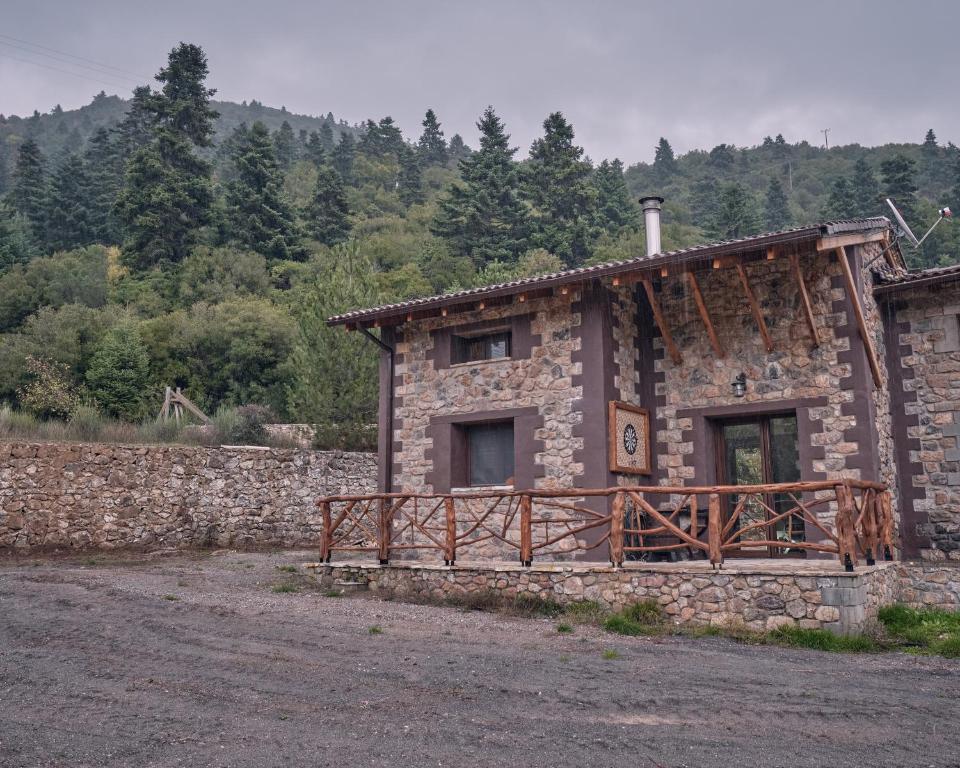 a stone building with a fence around it at oneiropagidasuites in Kalavrita