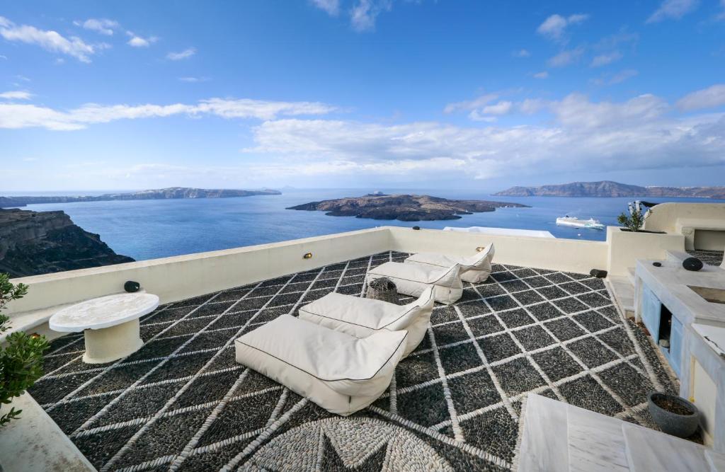 a balcony with chairs and a view of the water at 360 Blue in Fira