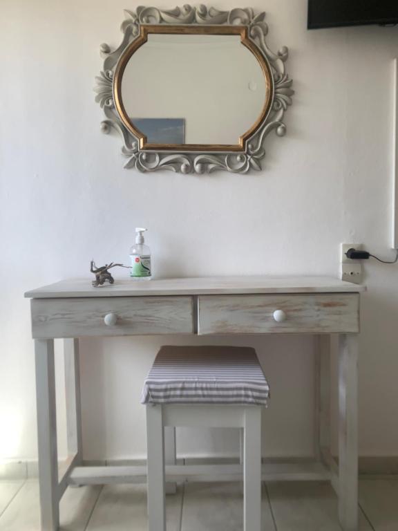 a dressing table with a mirror and a stool at Irene Komos in Pitsidia