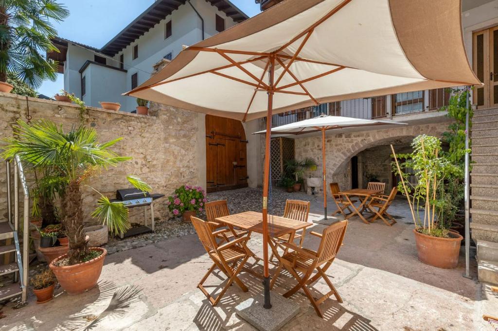 einen Tisch und Stühle mit Sonnenschirm auf einer Terrasse in der Unterkunft Appartamenti Sarasà in Arco