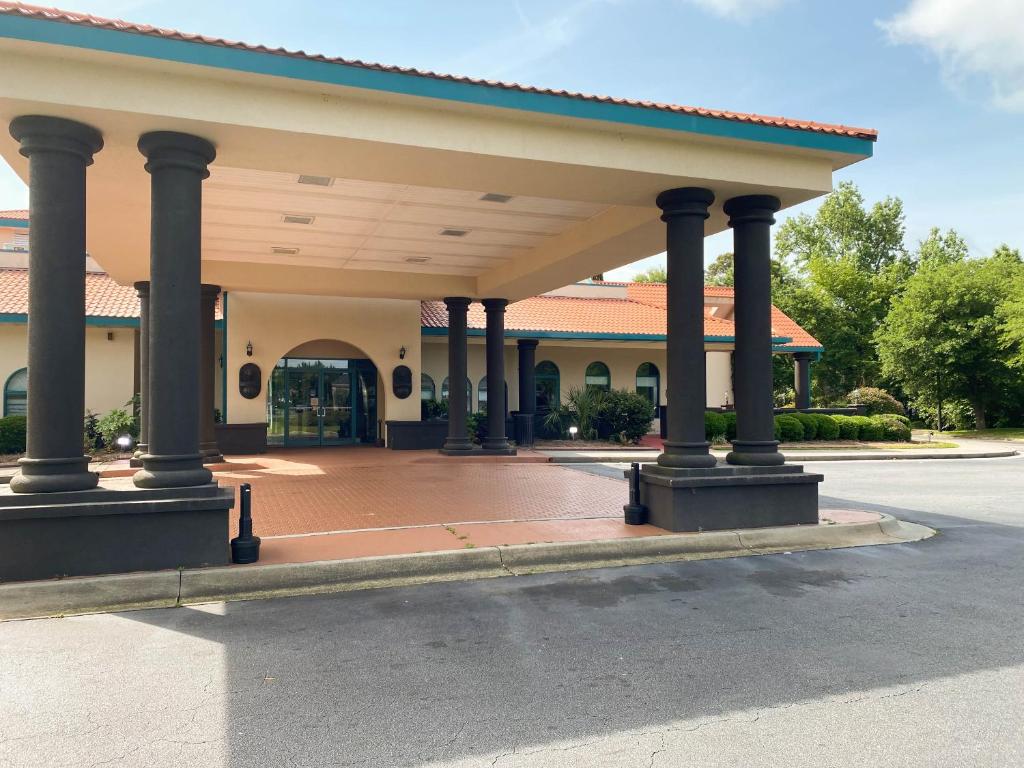 a building with a large pavilion with a street at Studio 6 Extended Stay - Savannah, GA - Gateway & I-95 in Savannah