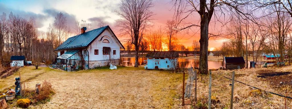 a small house in a field next to a lake at Romantic Spa Villa with Fireplace by the lake in Stjärnsund
