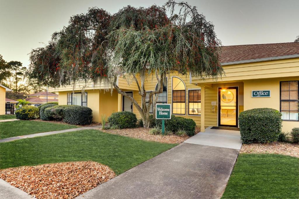 a yellow house with a sign in front of it at Mariners Suites - Kingsland in Kingsland