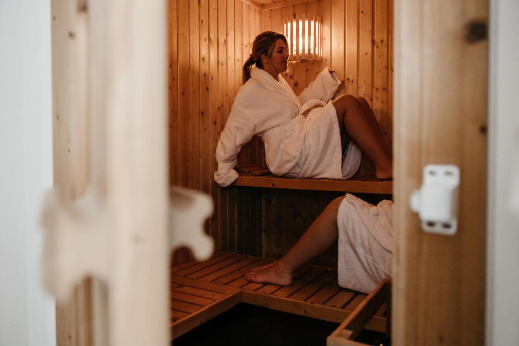 a woman sitting in a bed in a sauna at Landelijkhuisje in Deurne