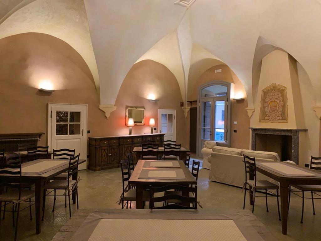 Cedegolo的住宿－Foresteria Antica Farmacia，一间带桌椅和壁炉的餐厅