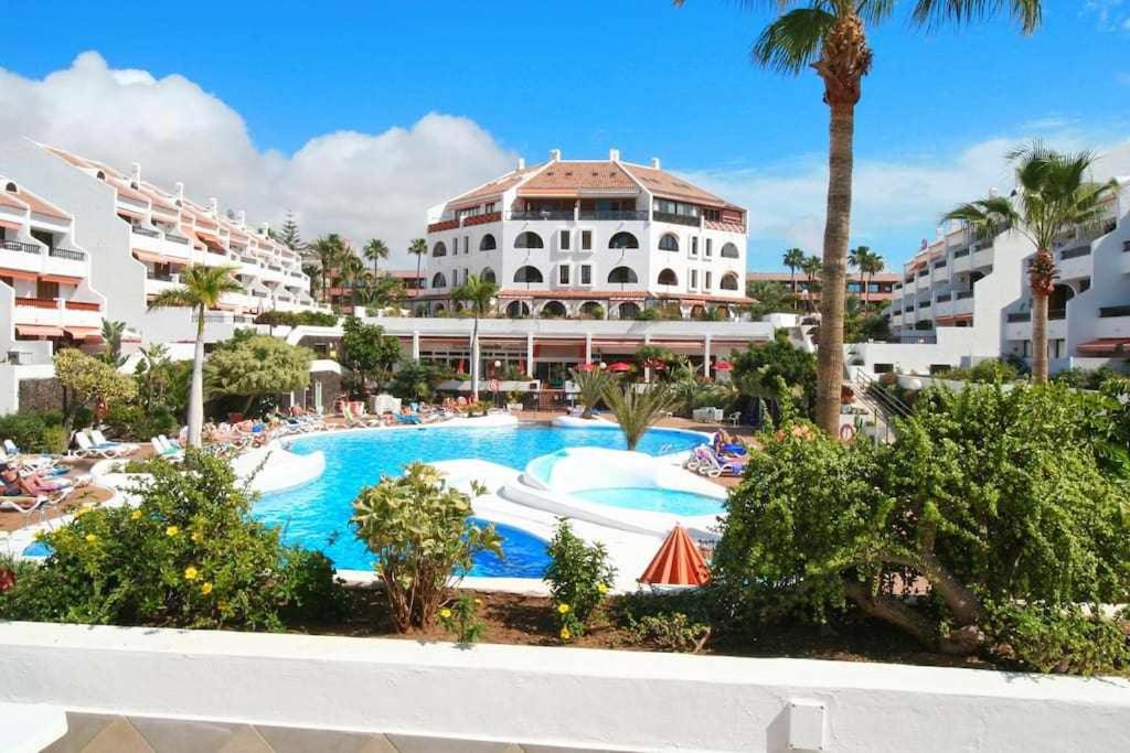 プラヤ・デ・ラス・アメリカスにあるParque Santiago 1 Villa114 Tenerife Rental and Salesのリゾート(建物の前にスイミングプールあり)