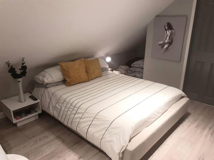 una camera da letto con un grande letto bianco di The Contemporary Studio a Bracknell