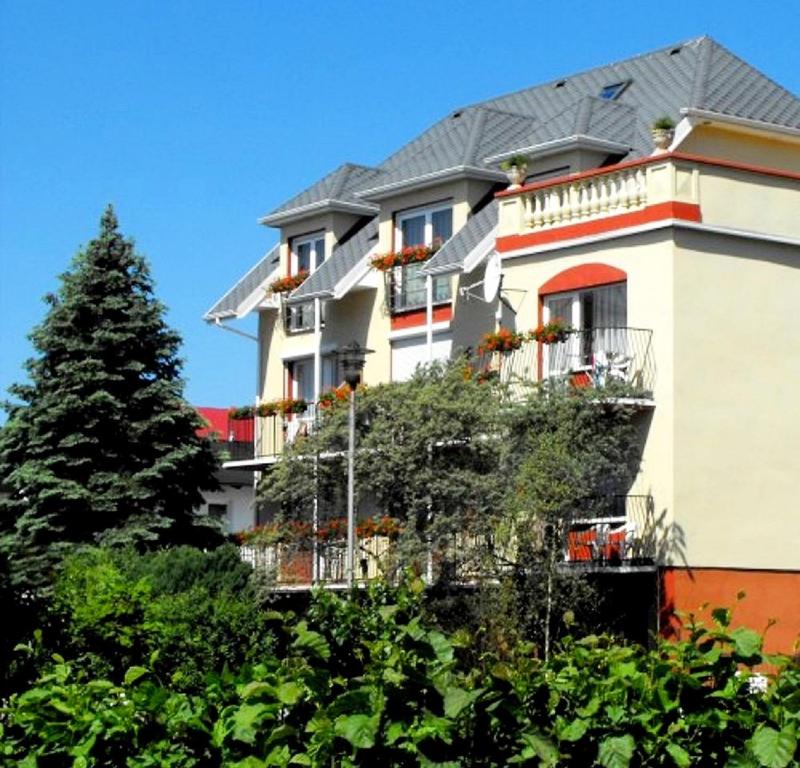 a large white building with a tree in front of it at Dom Wczasowy Sloneczko in Mielno