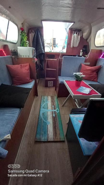 ein Wohnzimmer mit Sofas und einem Tisch in einem Wohnwagen in der Unterkunft Barco el viento in Barcelona