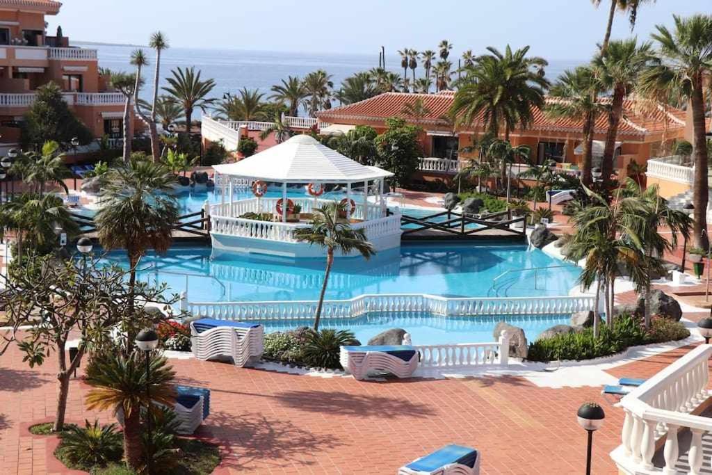 a resort pool with a gazebo and palm trees at Royal Gardens Studio 123 Tenerife Rental and Sales in Playa de las Americas