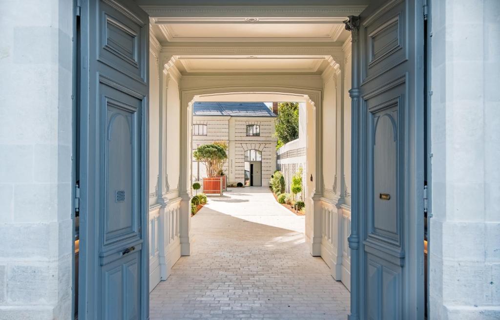 um arco que conduz a uma rua com um edifício em Les Trésorières em Tours