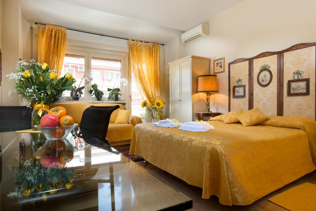 ローマにあるB&B All'Ombra di San Pietroのベッドルーム(黄色のベッド1台、ソファ付)
