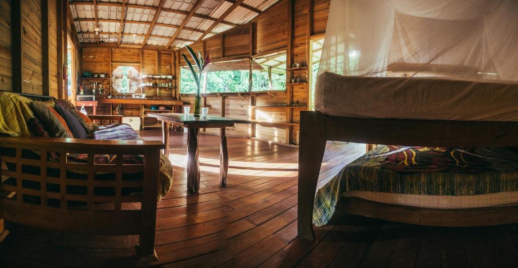 een slaapkamer met een bed en een tafel in een kamer bij ENSUEÑOS Natural Reserve Big House in Little Corn Island