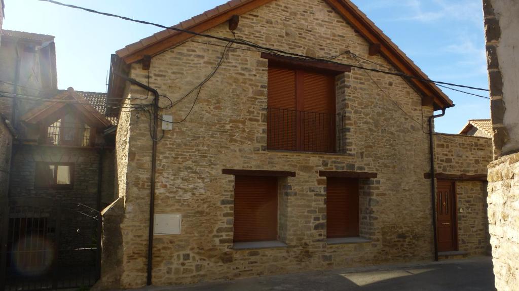 un edificio de ladrillo con cuatro ventanas. en Casa Rural Sardas - Sabiñanigo, en Sabiñánigo