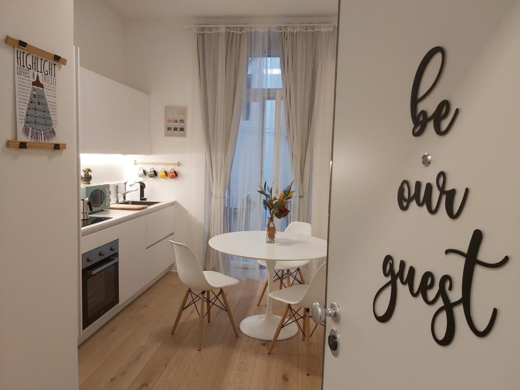 una cucina con tavolo e sedie e una sala da pranzo di La Casa di Adele - your Home in Trieste a Trieste