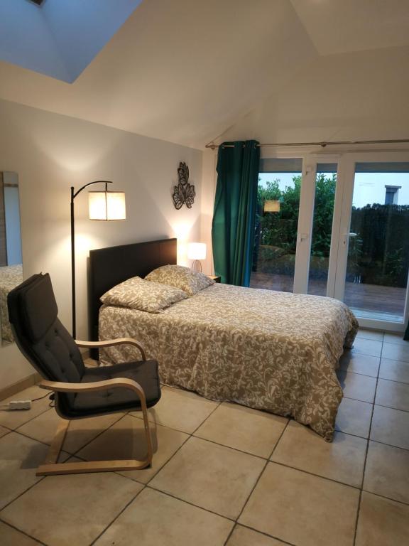 1 dormitorio con 2 camas, silla y ventana en Studio Terrasse - Parking gratuit, en Orléans