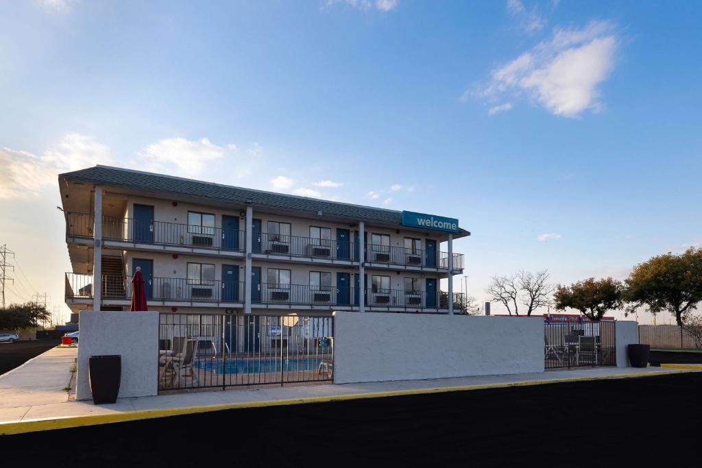 a large building with a fence in front of it at Motel 6-San Antonio, TX - West SeaWorld in San Antonio