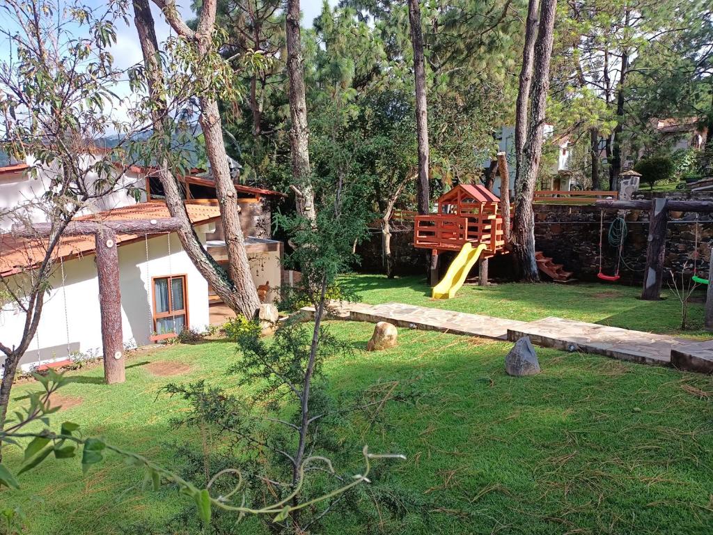 a yard with a playground and a house at Cabaña La Lomita in Mazamitla