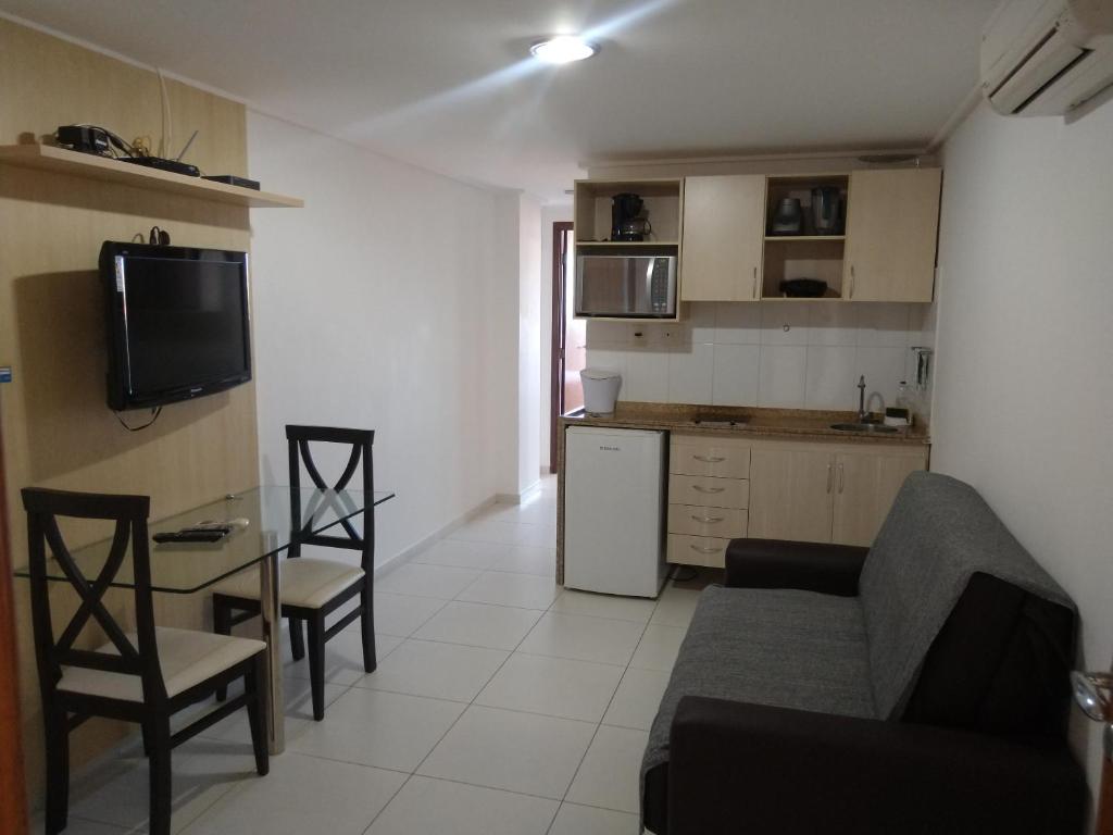 cocina y sala de estar con sofá y mesa en Manaíra Palace 419, en João Pessoa