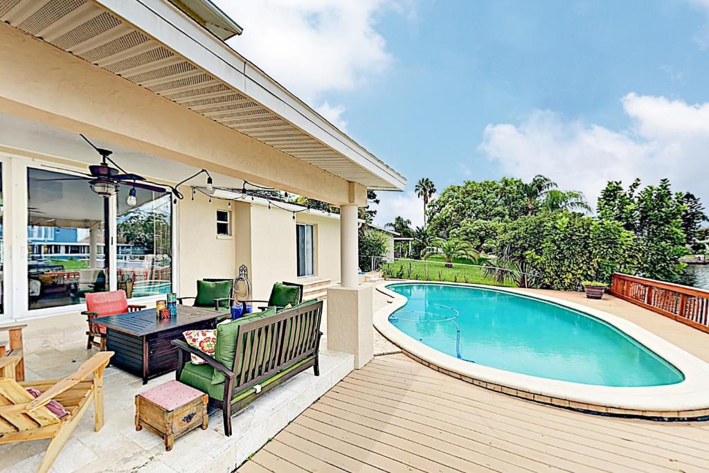 eine Terrasse mit einem Pool, einem Tisch und Stühlen in der Unterkunft Garden Castle in Tampa