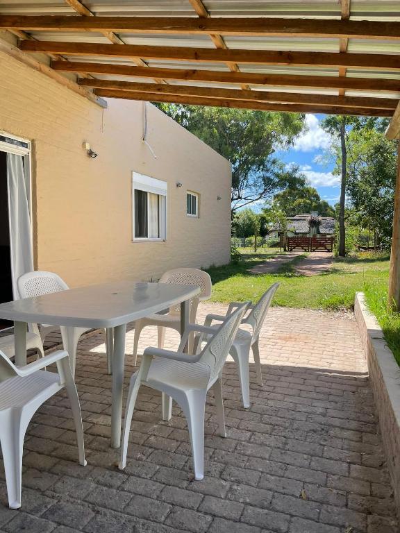a white table and chairs on a brick patio at la vidurria -rre in Piriápolis