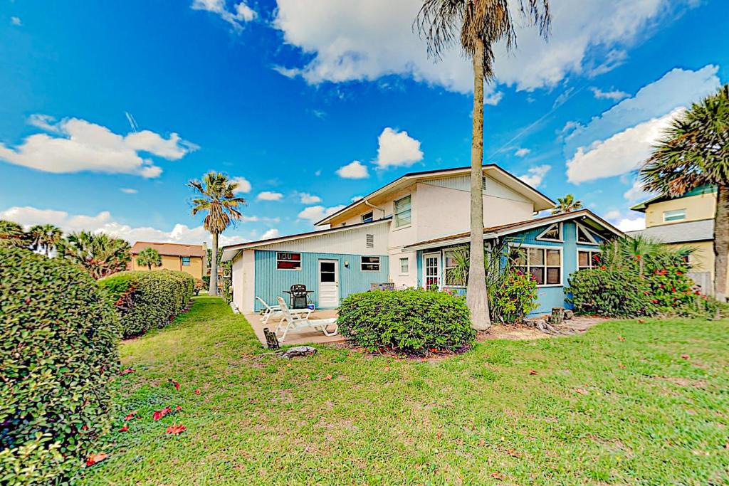 a house with a palm tree in a yard at Seaside Cottage in St. Augustine